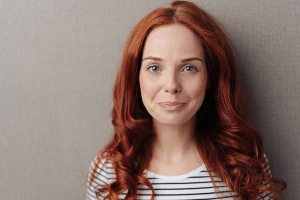 Young woman with closed lips smile.